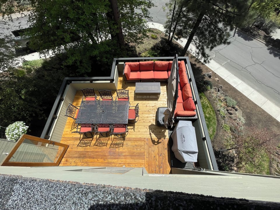 Spacious mountain-view deck with dining, grill, and lounge for gathering