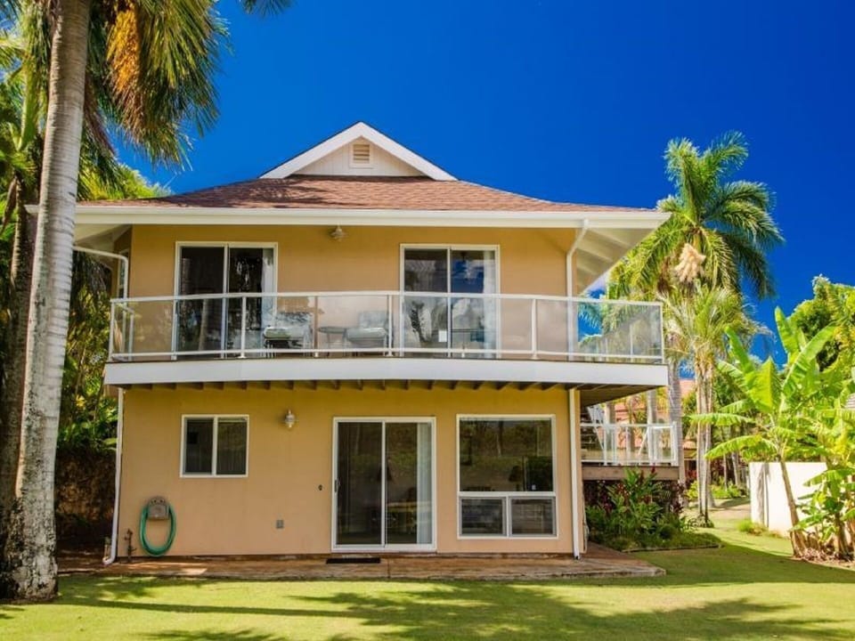 Back side of home with upper lanai that wraps around 