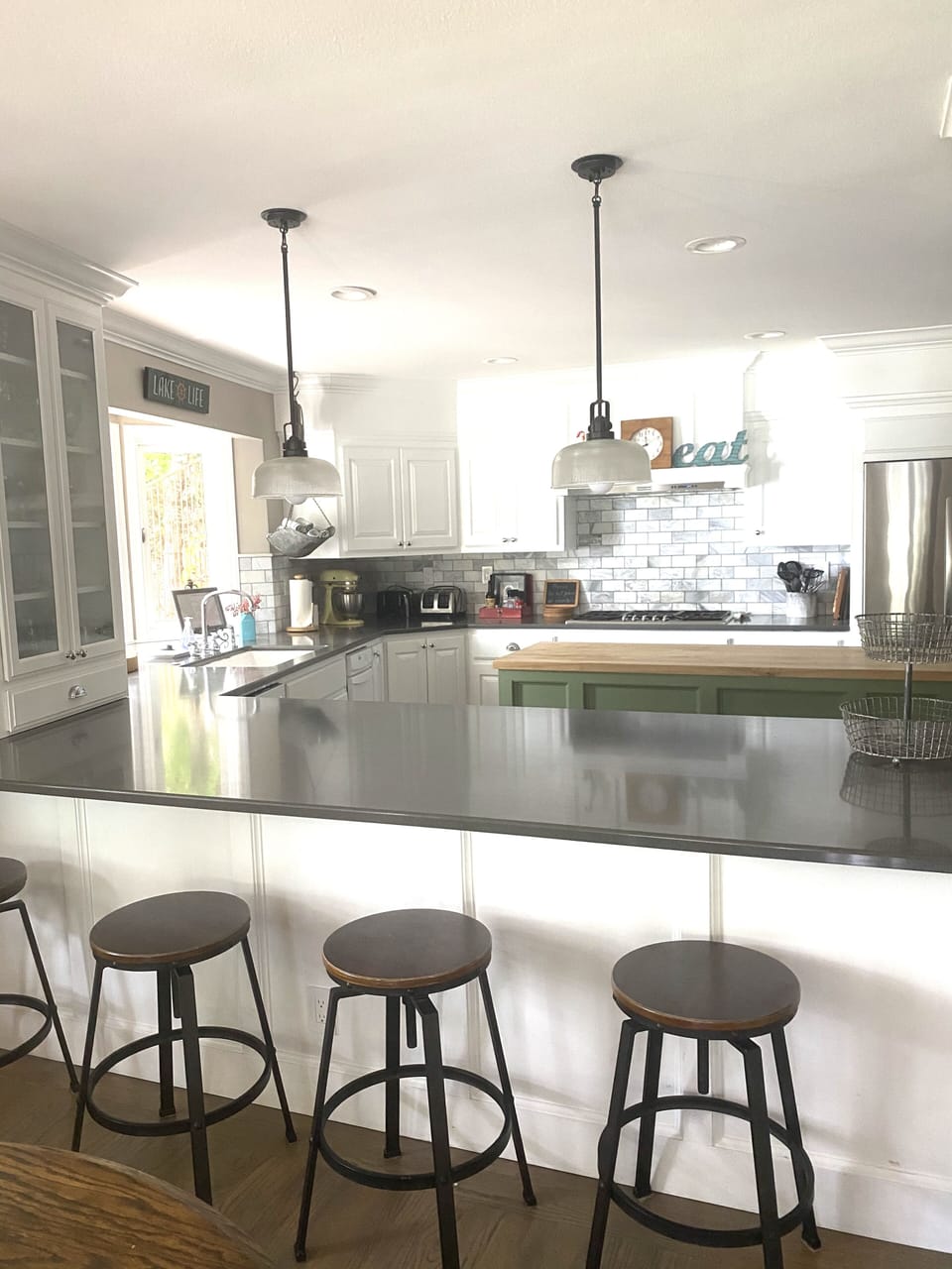 Kitchen peninsula  w/stools  overlooking island, 5-burner stove & refrigerator