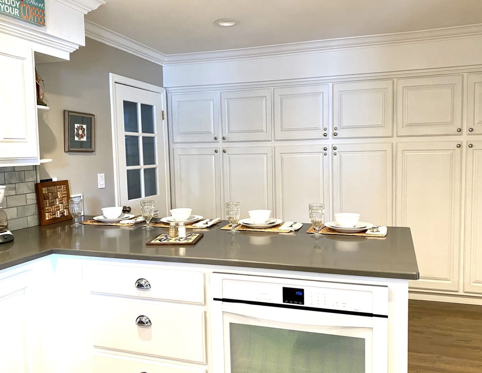 Kitchen peninsula w/4  seats for watching meal prep. Large pantry storage area.