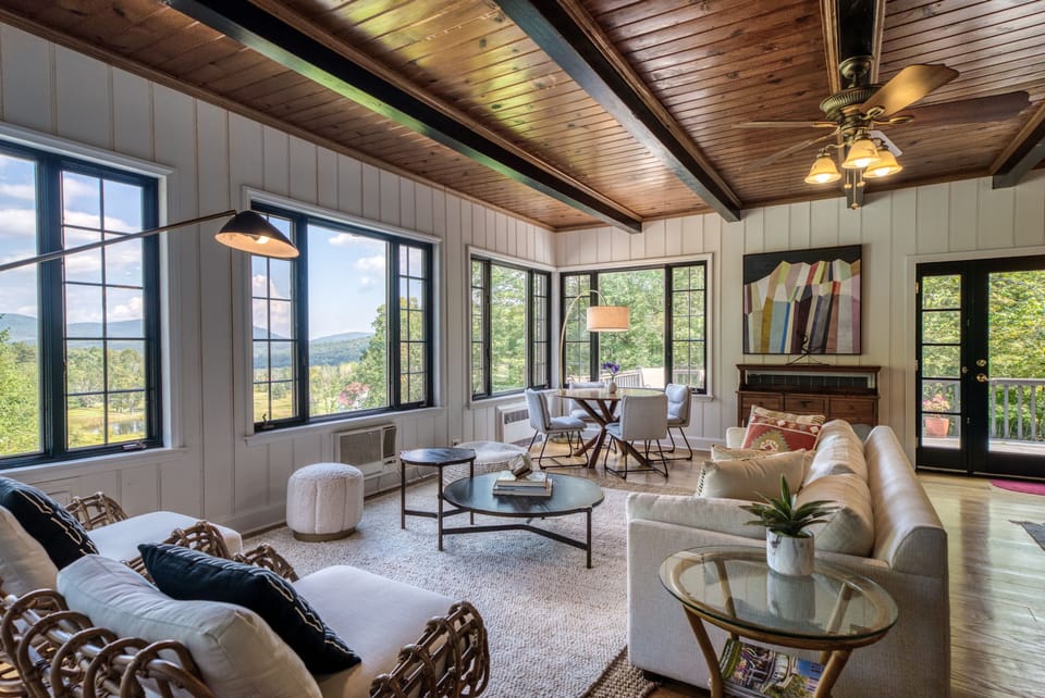 The sun flooded living room has spectacular views and leads to a large deck