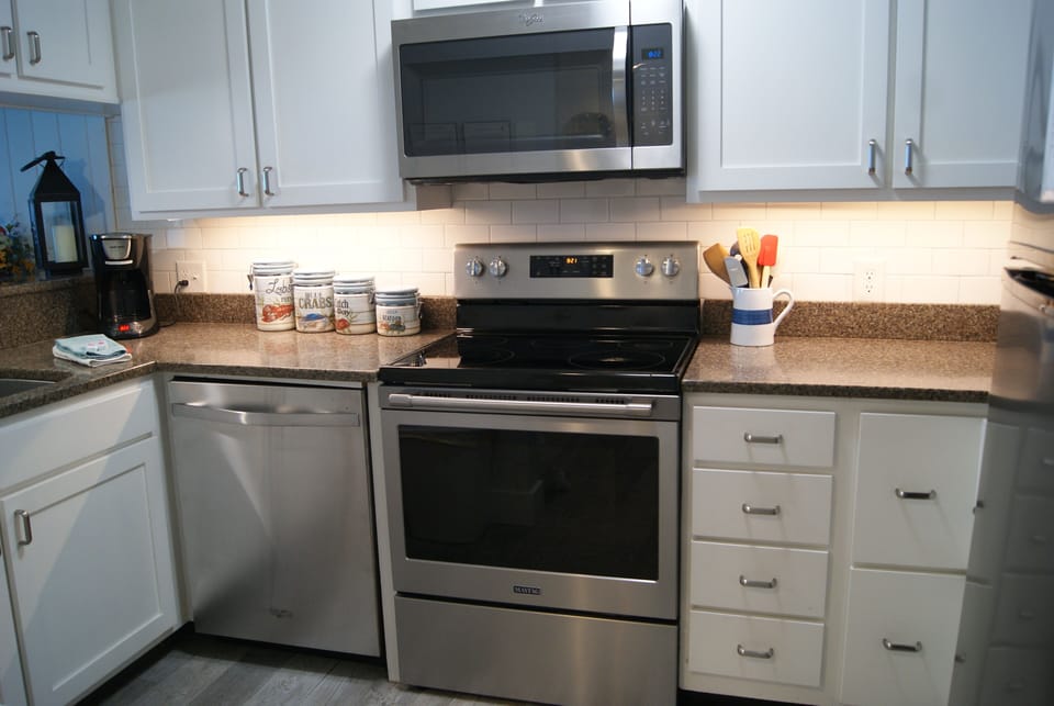Kitchen with stainless steel dishwasher, range/oven, and microwave.