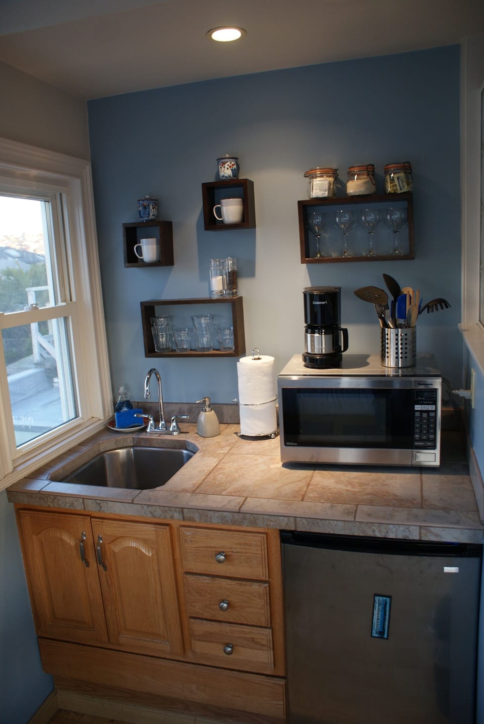 Closeup of kitchen area with, refrigerator, microwave, sink, coffee maker, etc.