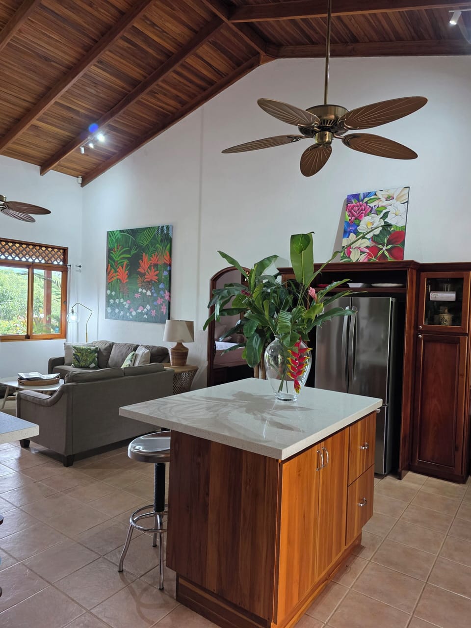 Open floor plan kitchen/living area with vaulted ceilings and views to the pool and mountain range.