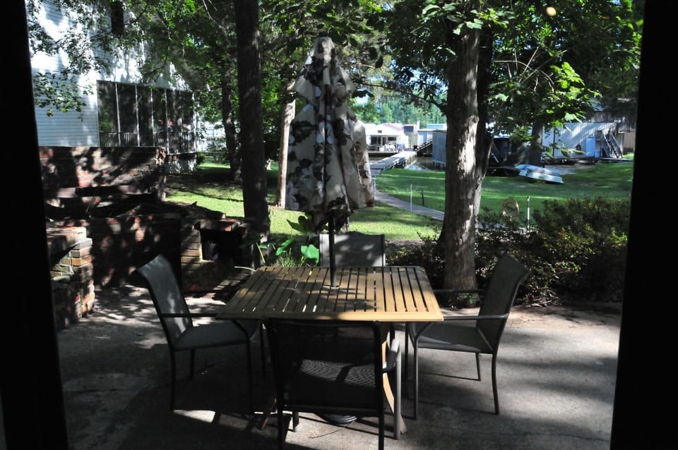 Large patio with table, umbrella, 4 dining chairs, 4 adirondack chairs.
