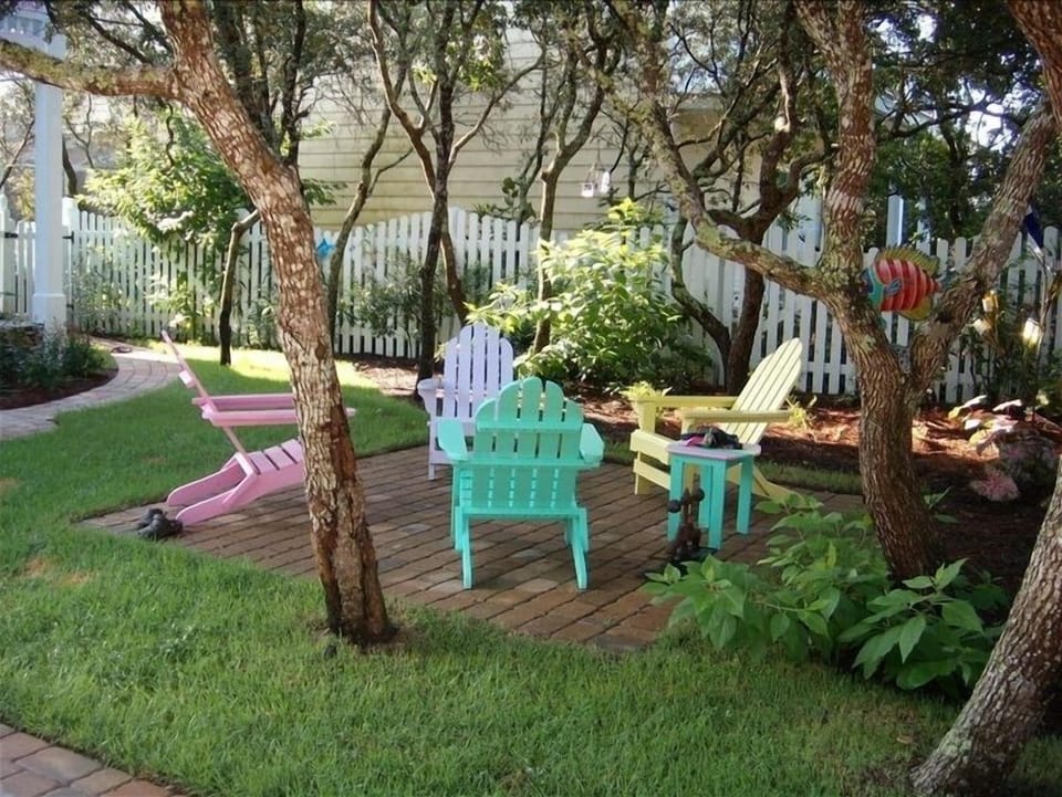 Sitting area and hammock under shade trees in front yard.