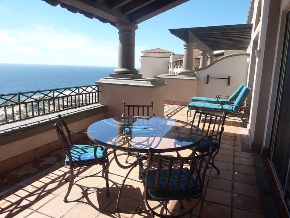 Balcony with dining table and chaise lounge chairs
