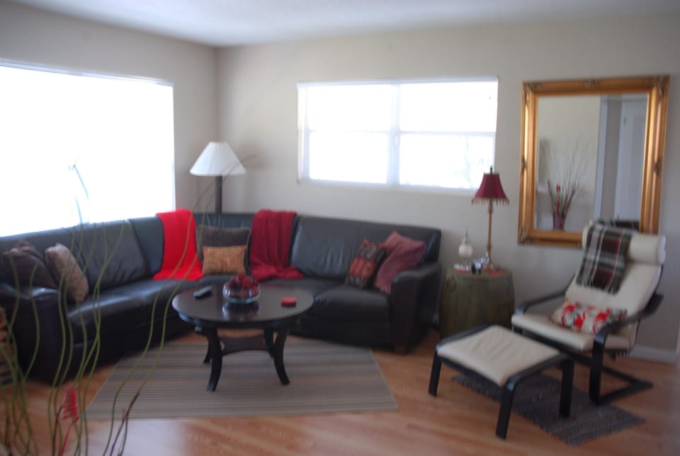 Living area with large picture windows looking out onto  tropical landscaping