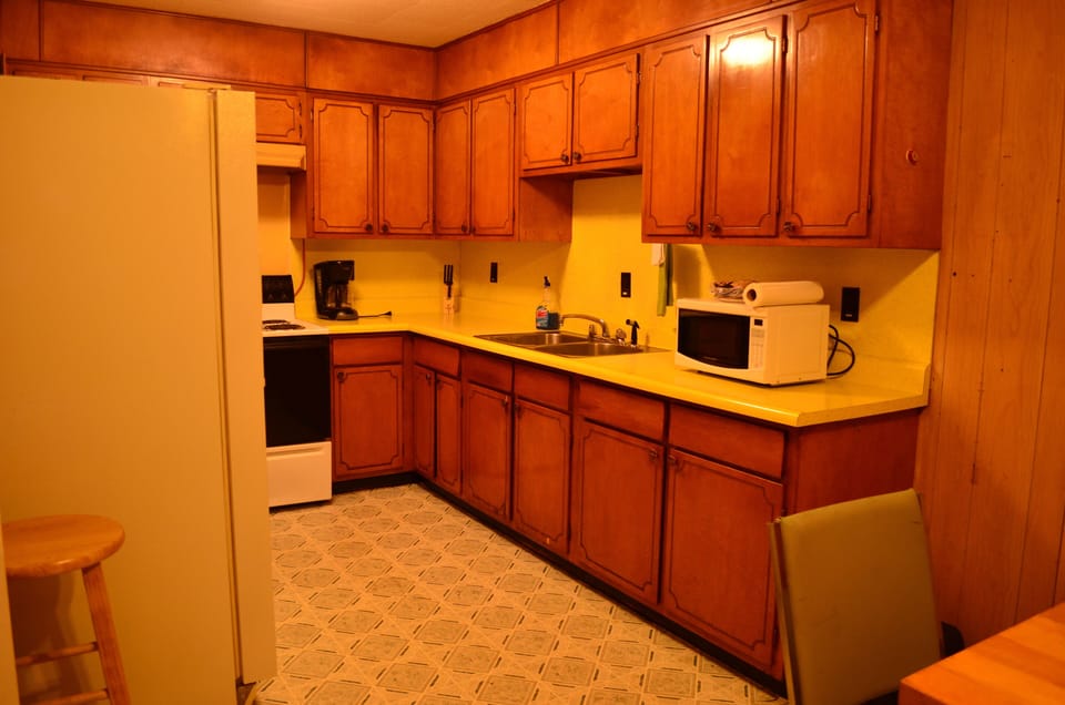 Kitchen is stocked with pots, pans, utensils, and dishes.