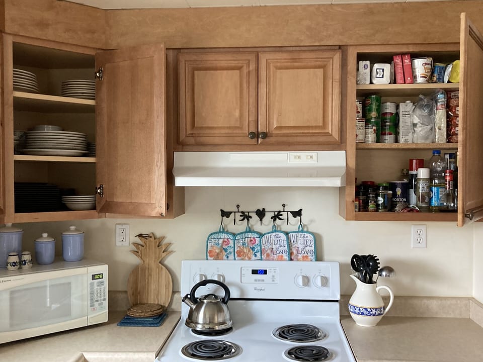 Seasonings and plenty of dish ware. Foil and saran wrap in drawer of small table