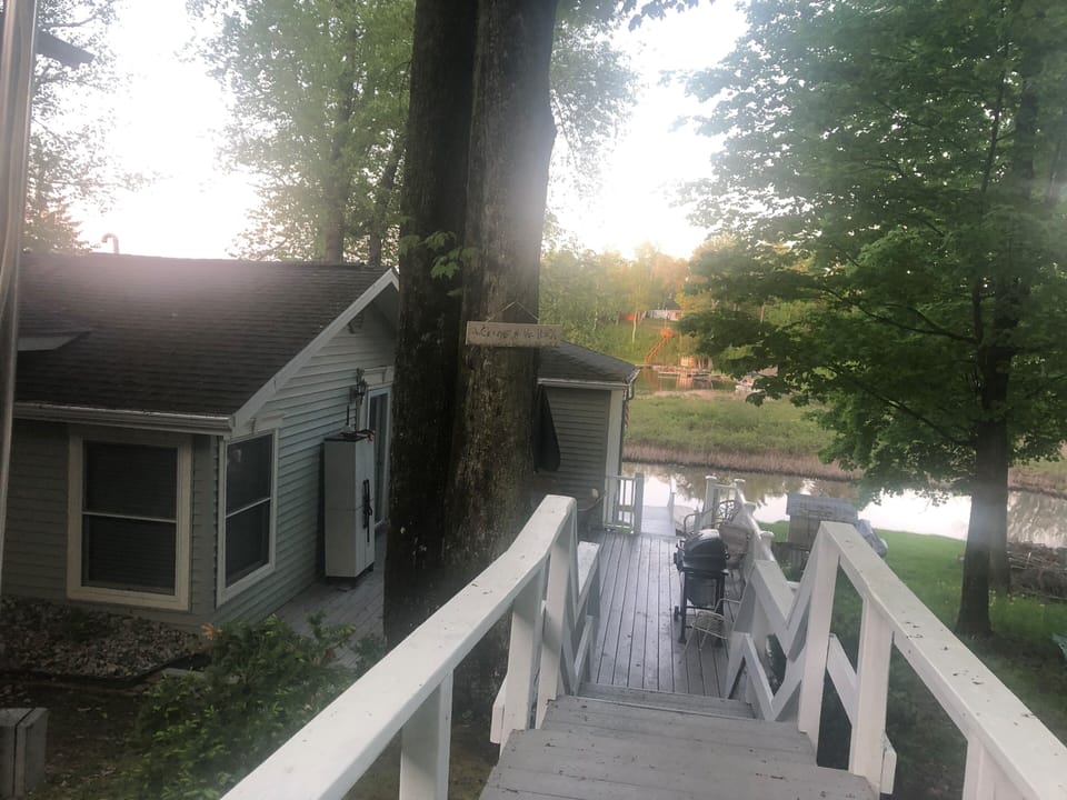 View of new decking replaced 2020 showing outdoor steps to back deck & lake.