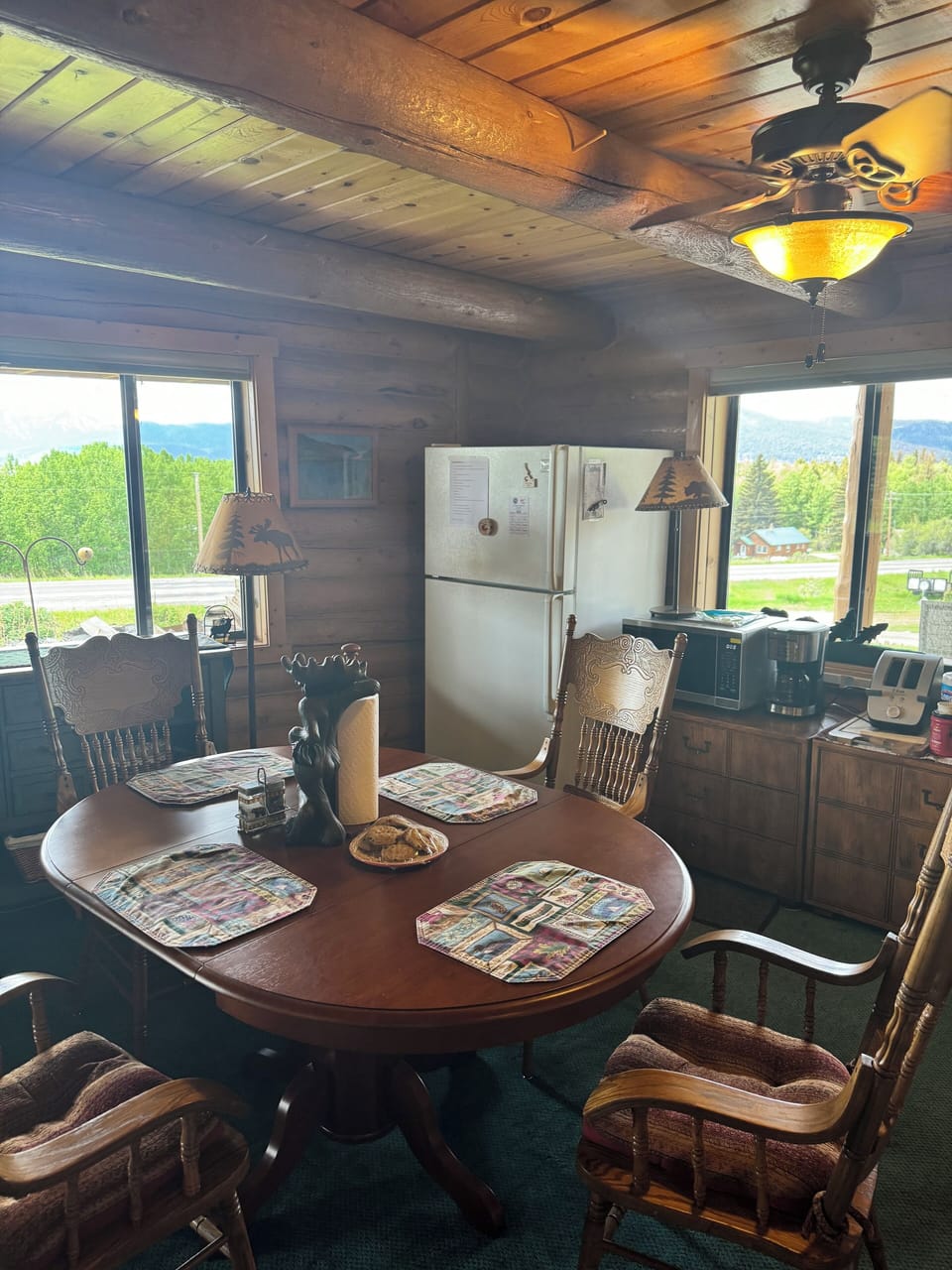 Dining table, coffee bar, and refrigerator.
