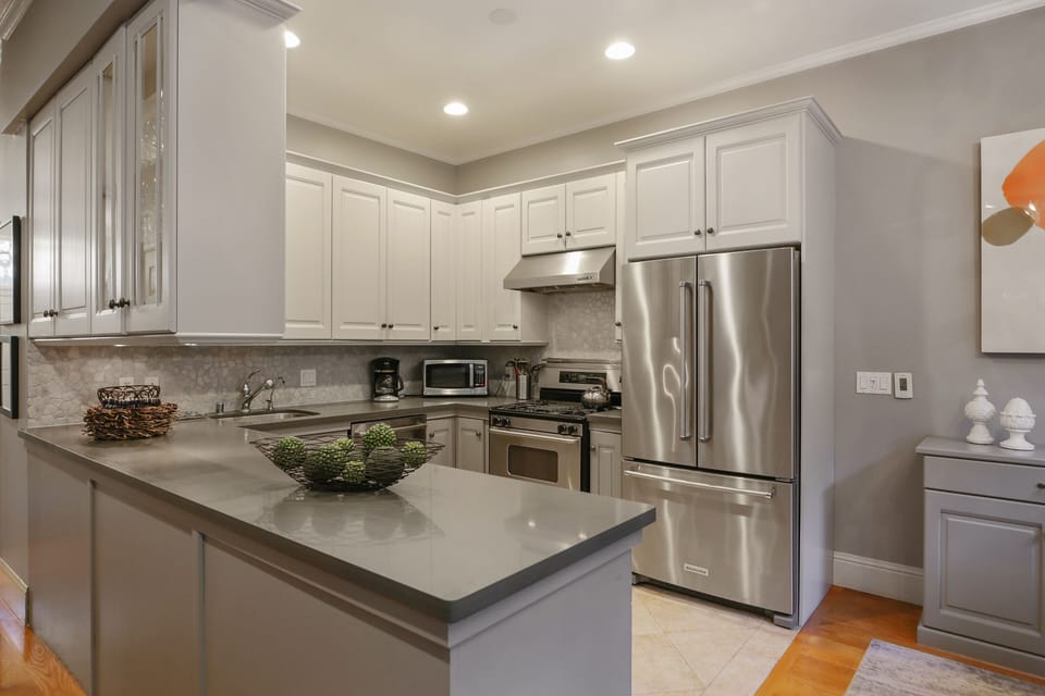 Fully equipped kitchen and BBQ gas grill on patio outside sliding doors.