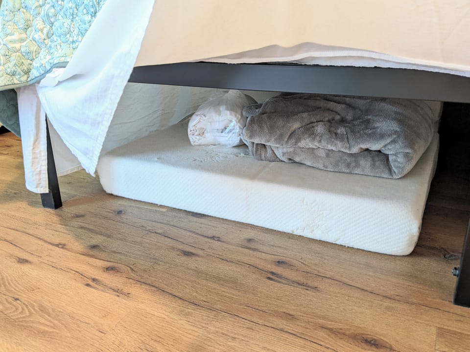 two floor mattresses for children along with bedding are under the master bed.  