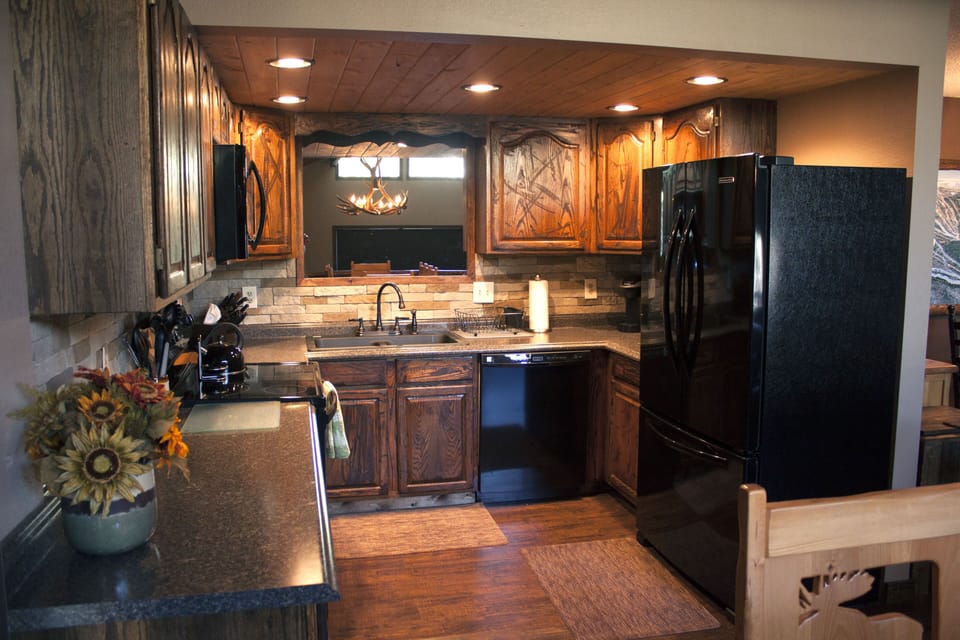 Kitchen, custom cabinets, fridge, stove, and microwave.