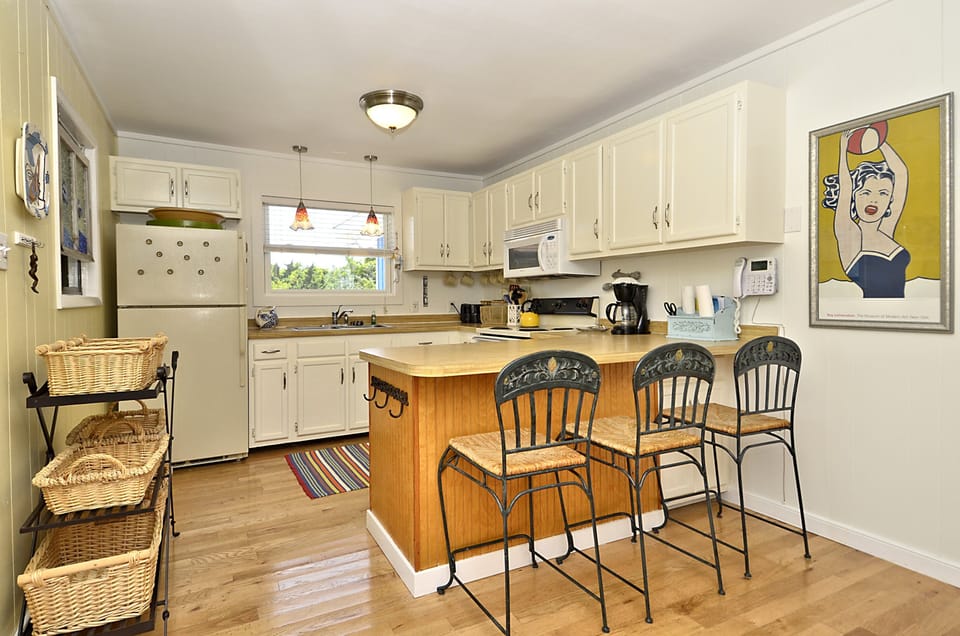 Kitchen with bar seating.  Well stocked with cook ware and dining ware
