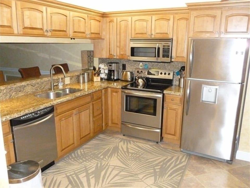 new kitchen with granite counters and stainless steel appliances