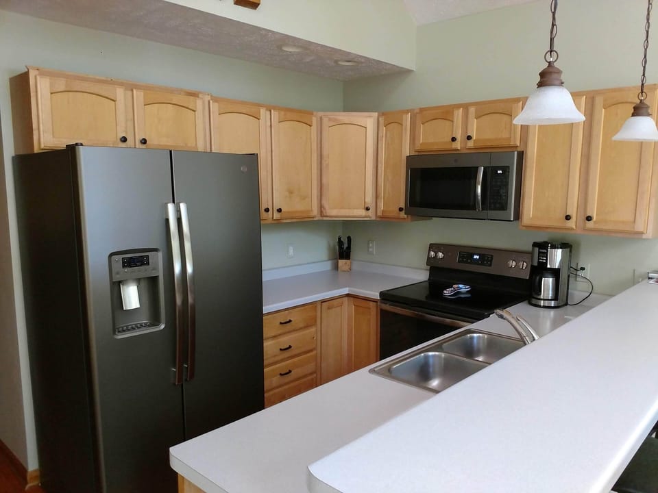 Full kitchen - dishwasher, stove, fridge with ice and water, cookware, dishes.