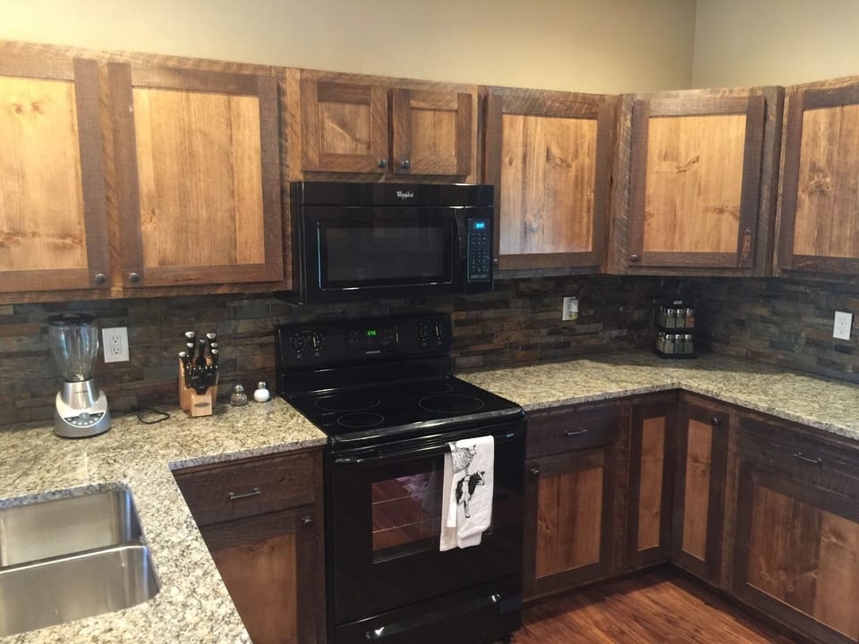 Kitchen with stacked stone backsplash and granite countertops.