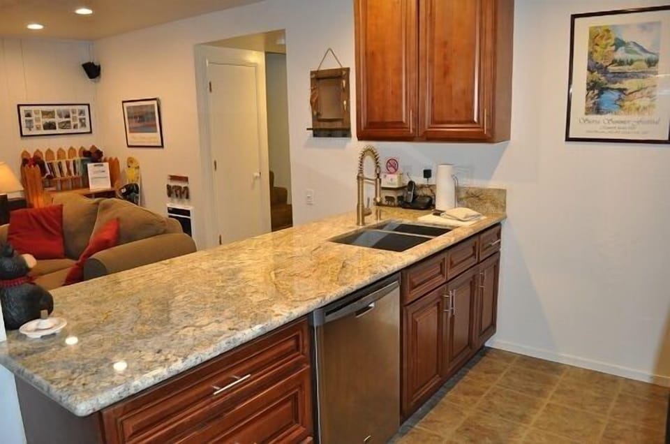 Large kitchen peninsula with slab granite open to living area