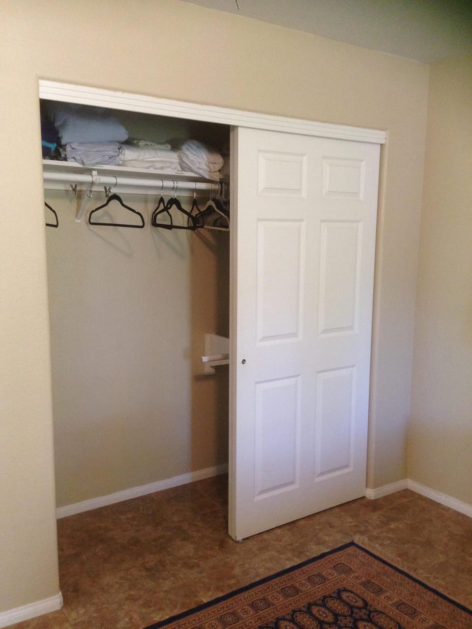 Large master bedroom closet with extra linens and beach towels.