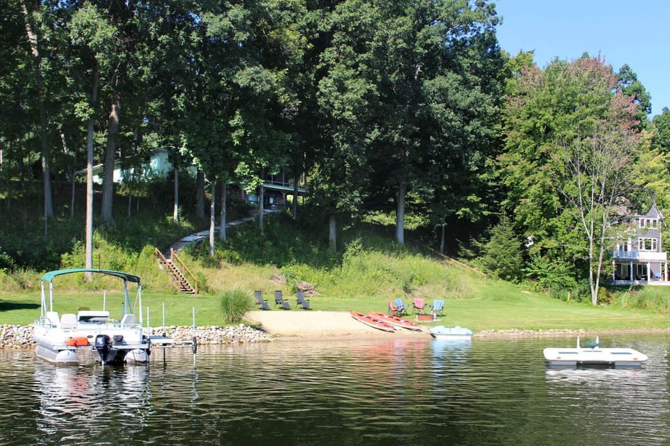 Sitting on a shady perch, the house overlooks a beach, yard, dock and raft.