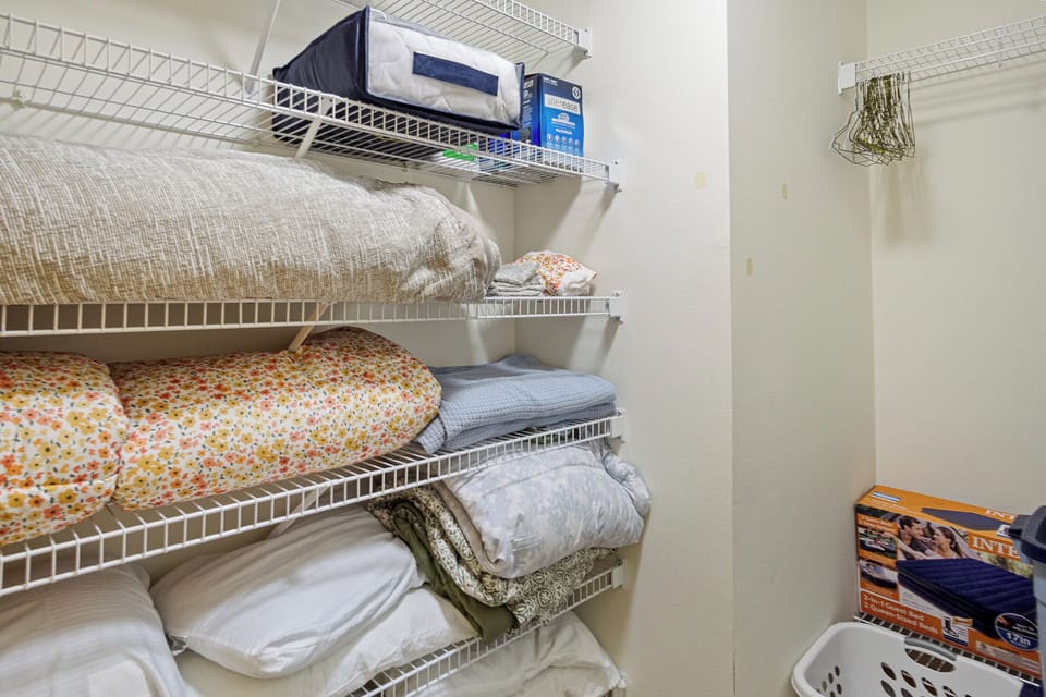 Primary bedroom with closet with extra linens.