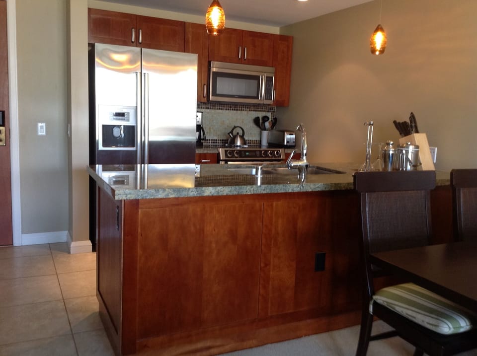 Open kitchen with stainless steel Bosch appliances and granite counter tops.