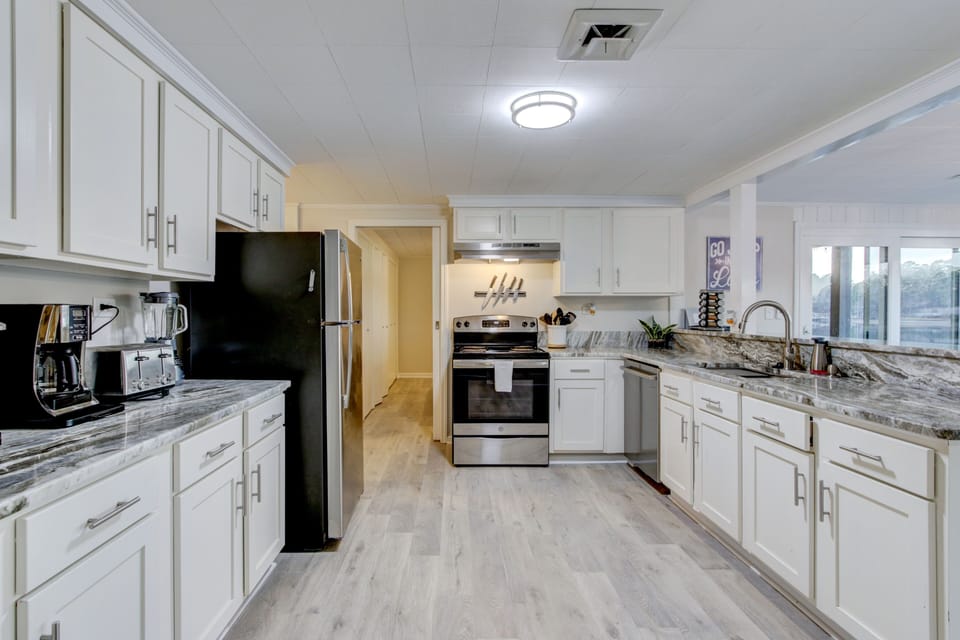 Kitchen with electric stove/oven; blender, toaster, microwave & 2 coffee makers.