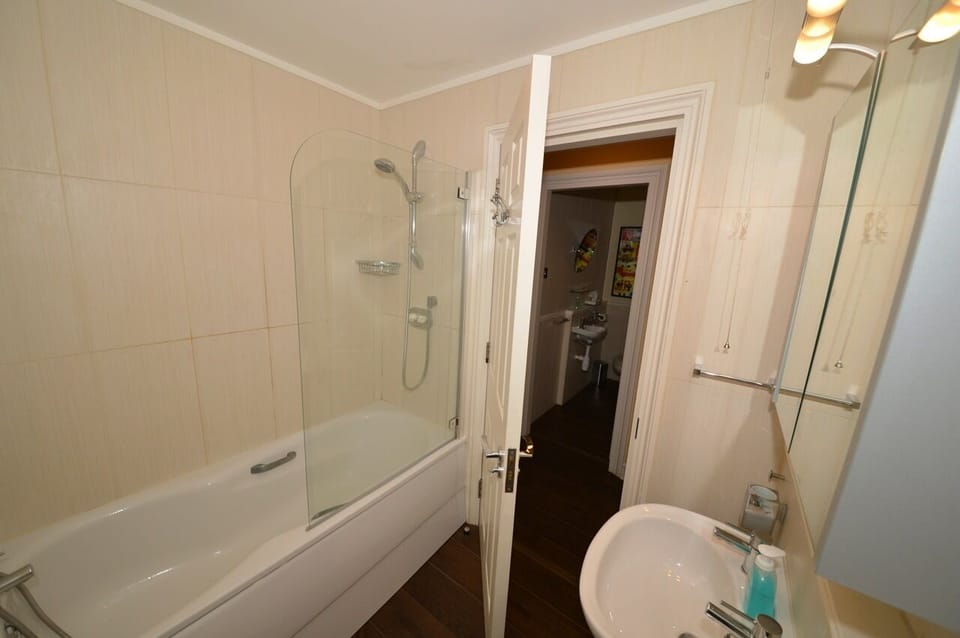 Bathroom (showing shower over bath, hand basin but toilet out of sight)