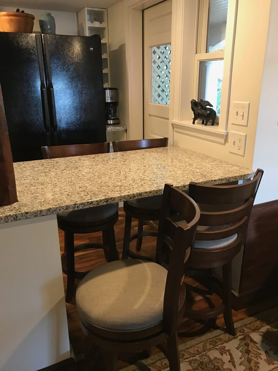 kitchen peninsula with 4 stools.  Secondary door to apartment in kitchen