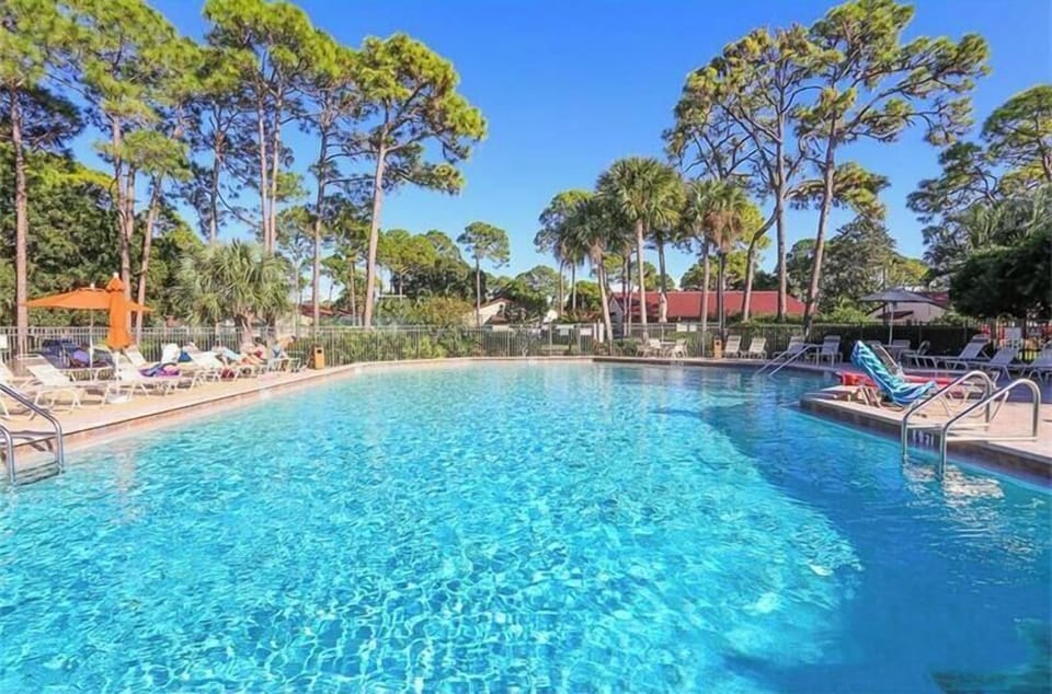 Heated Pool and deck with tables, chairs, umbrellas and lounge chairs