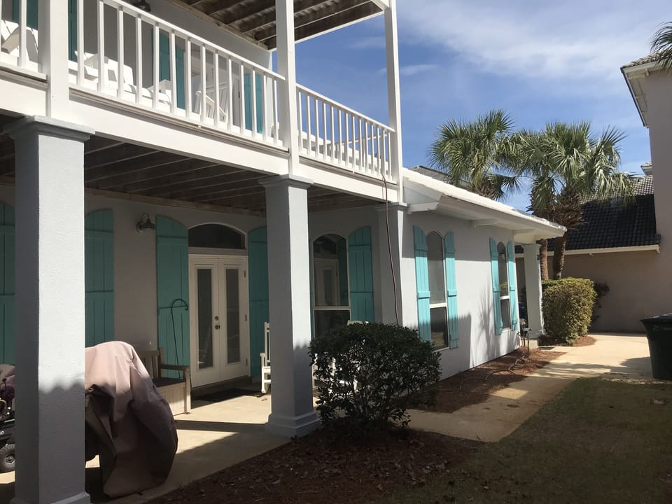 Porch with BBQ, patio furniture, beach wagons, & storage bench with beach toys