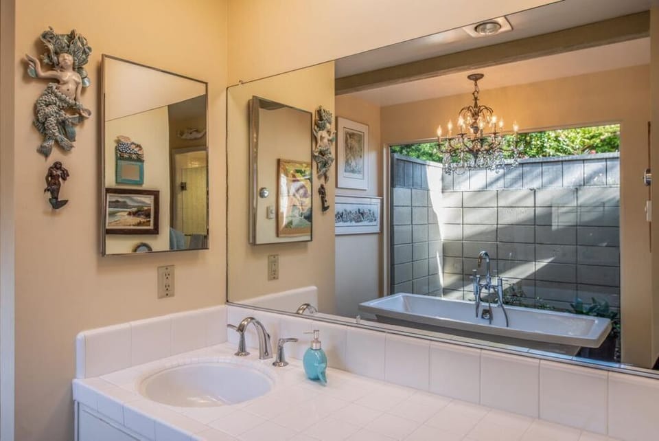 Master Bath with reflective view of the large tub and outdoor garden area