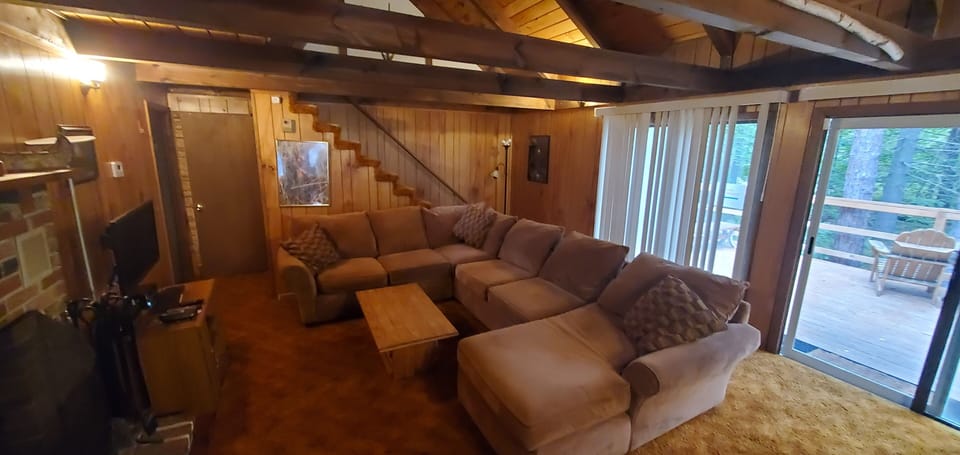 Open concept living room, high ceilings, flat screen TV, fireplace. 