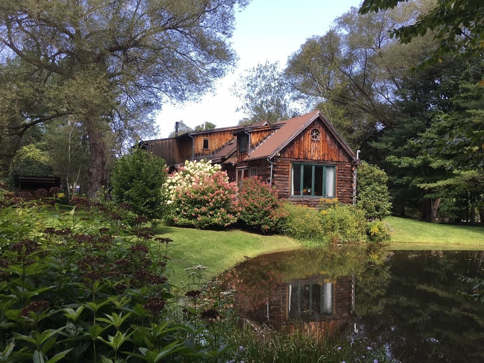 Unique log home perched above a pond, surrounded by stunning gardens & orchard