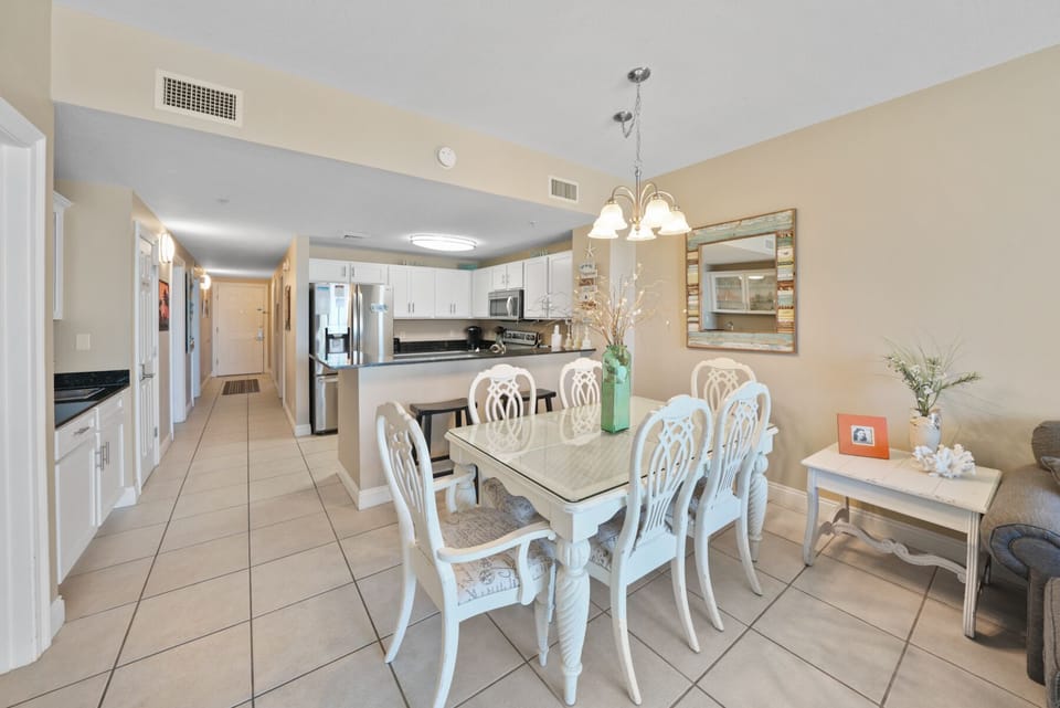 Gather around your elegant dining table for memorable meals in this bright, open-concept space with modern kitchen and coastal charm.
