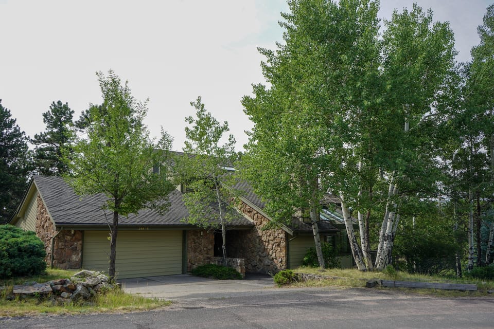 Front summer view of Evergreen Home on cul-de-sac