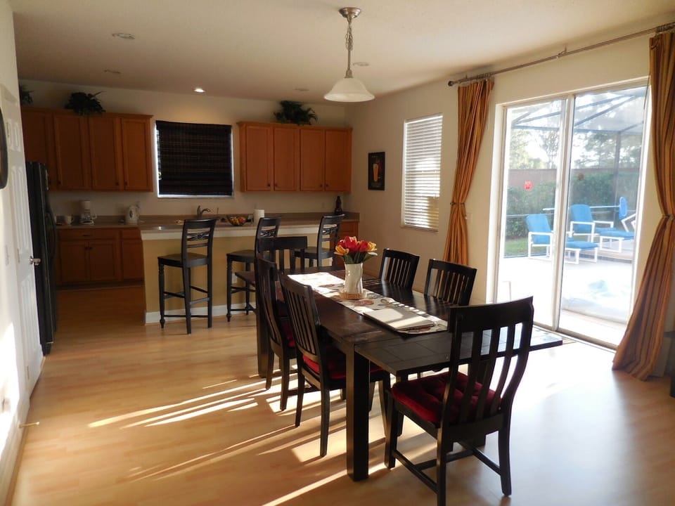 This view is the dining area with kitchen in background, slider to pool on right