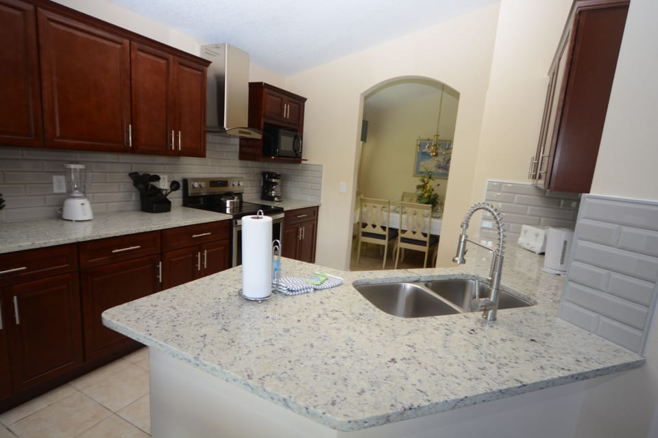 kitchen with granite worktops and stainless steel equipment