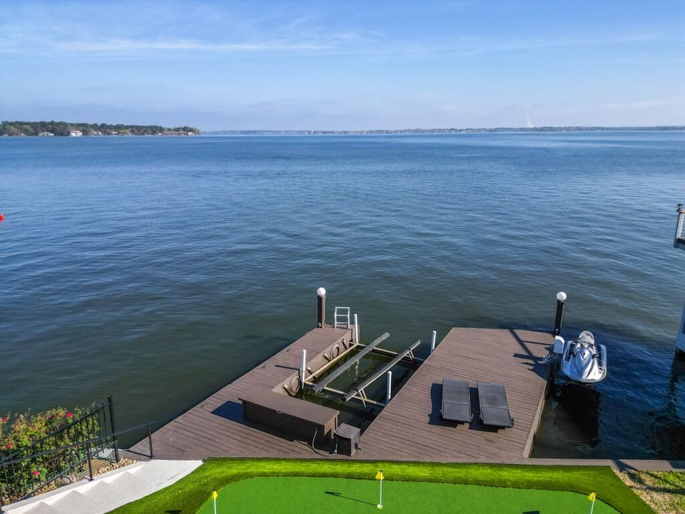 Private dock with boat lift, lounge chairs and ladder to access the lake