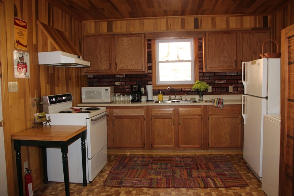 Fully equipped kitchen with small washer and dryer.