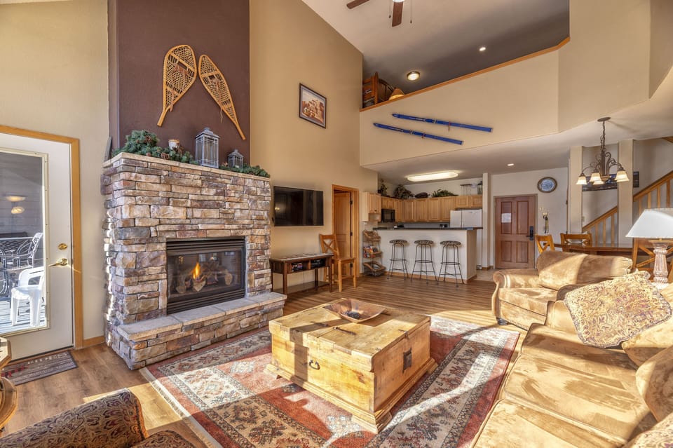 Main living area with stone fireplace, flat screen TV, and Queen fold out sofa.