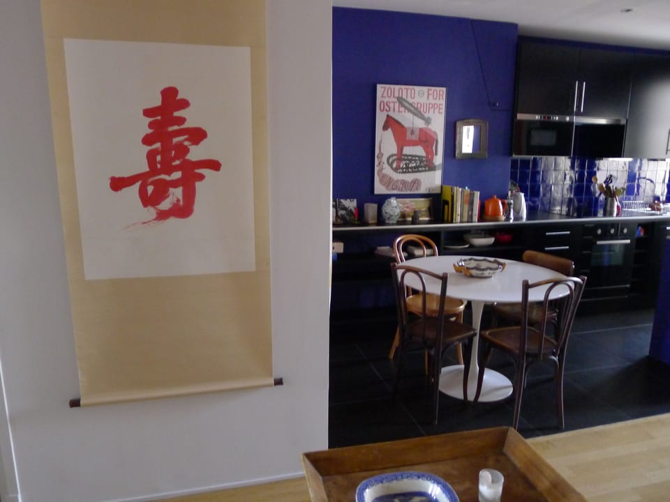 towards the kitchen, the bathroom is on the left of the chinese calligraphy