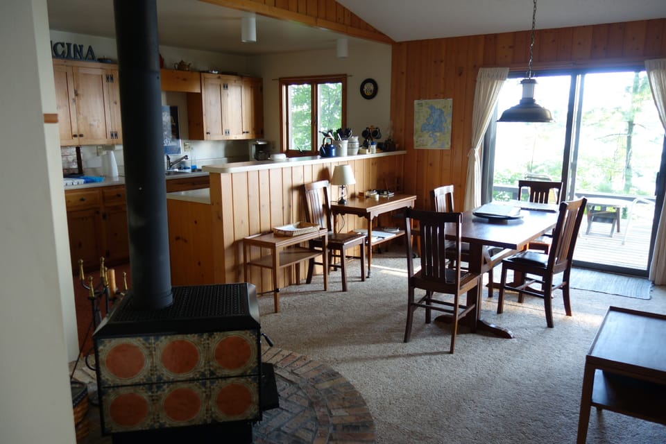 View of Dining Area, Wood Stove and Kitchen from Entry Door