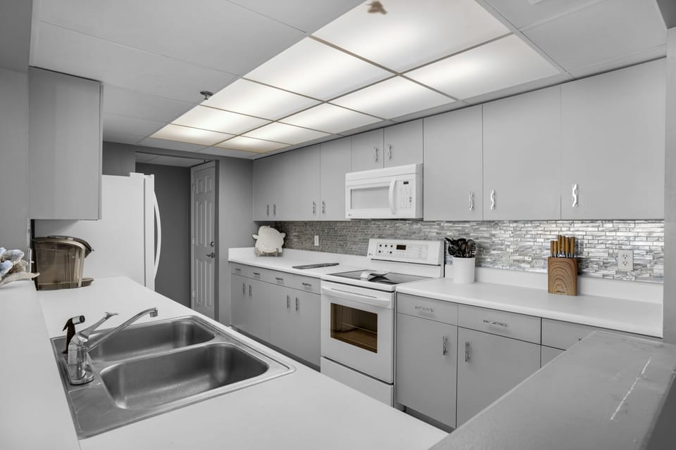 Kitchen is fully stocked with new dishes, glassware, pots and pans.