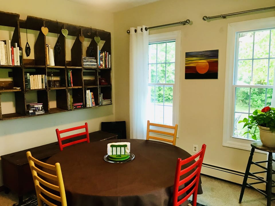 Dining room with round, conversation-style table. 4 chairs, & 4 more available. 