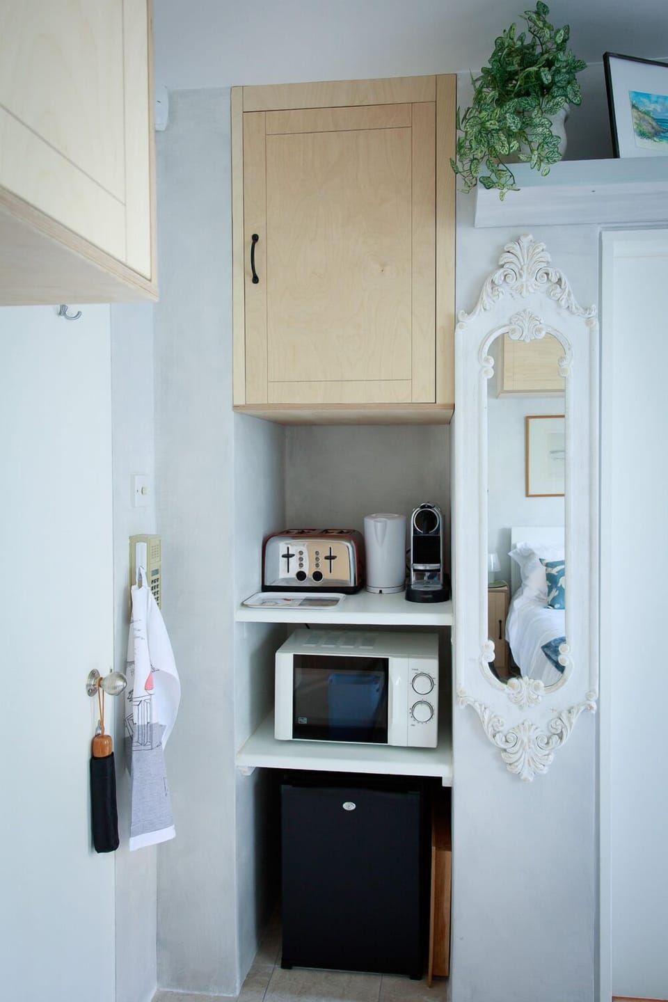 Kitchenette with fridge, microwave, toaster, kettle, Nespresso machine.