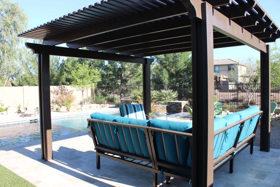 Very comfortable sofa and chairs under a pergola providing cool shade