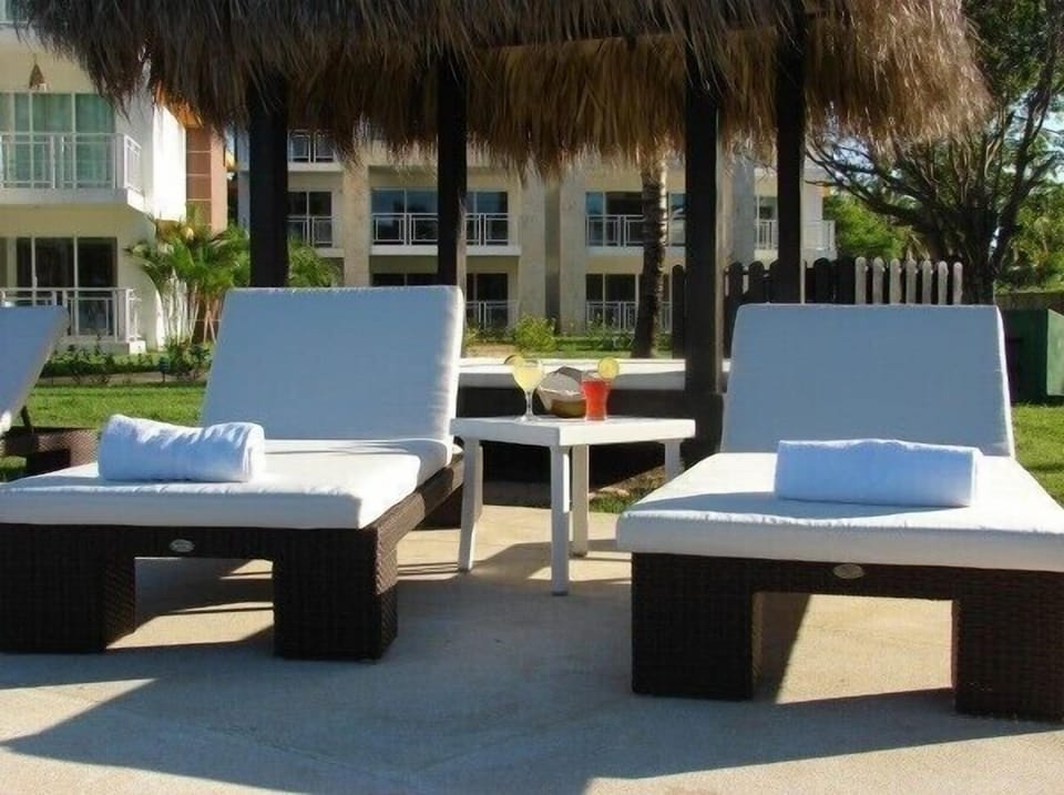 The sun loungers at the pool area with one of the palapas behind